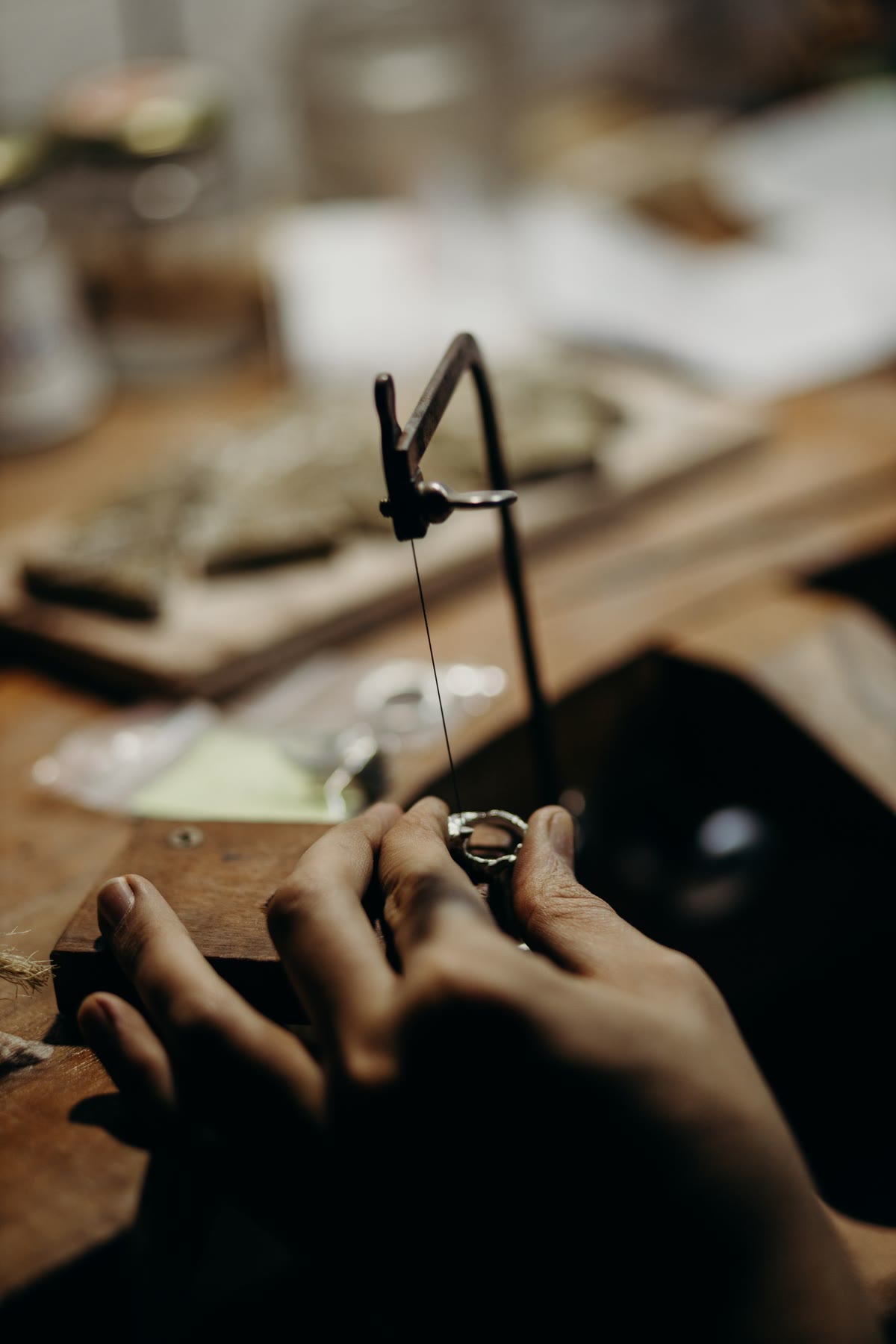A hand holding a cast metal tree of rings ready to be cut